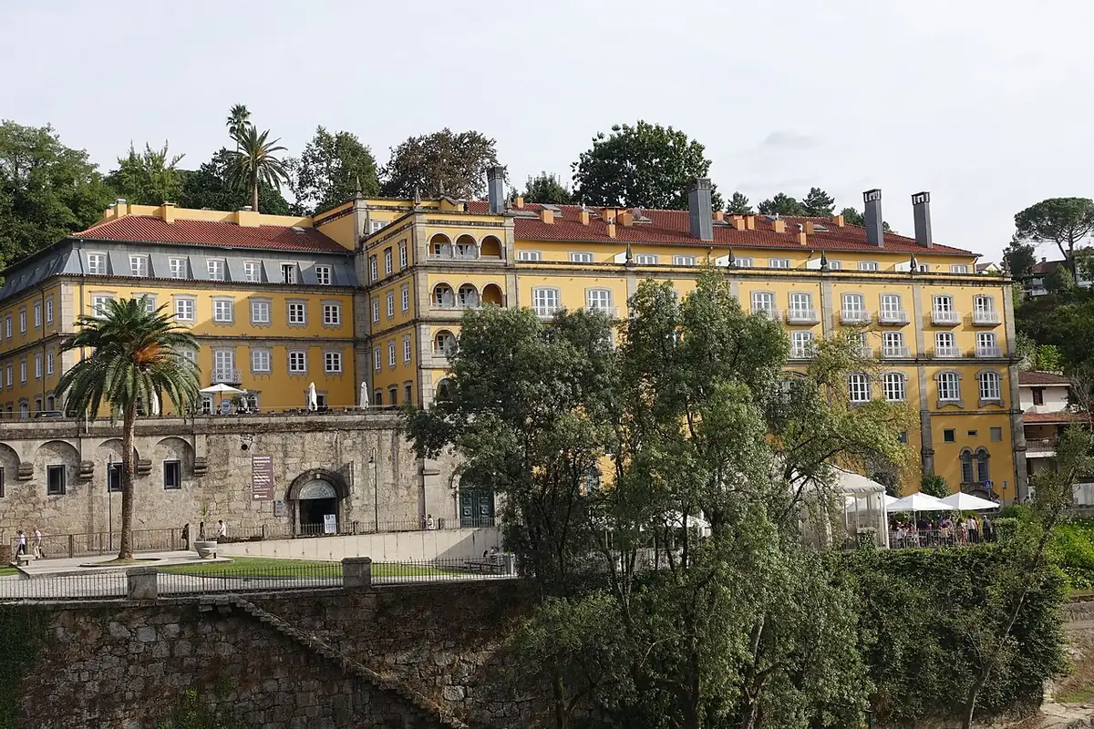 Yellow facade of Casa da Calçada above the riverside walls in Amarante