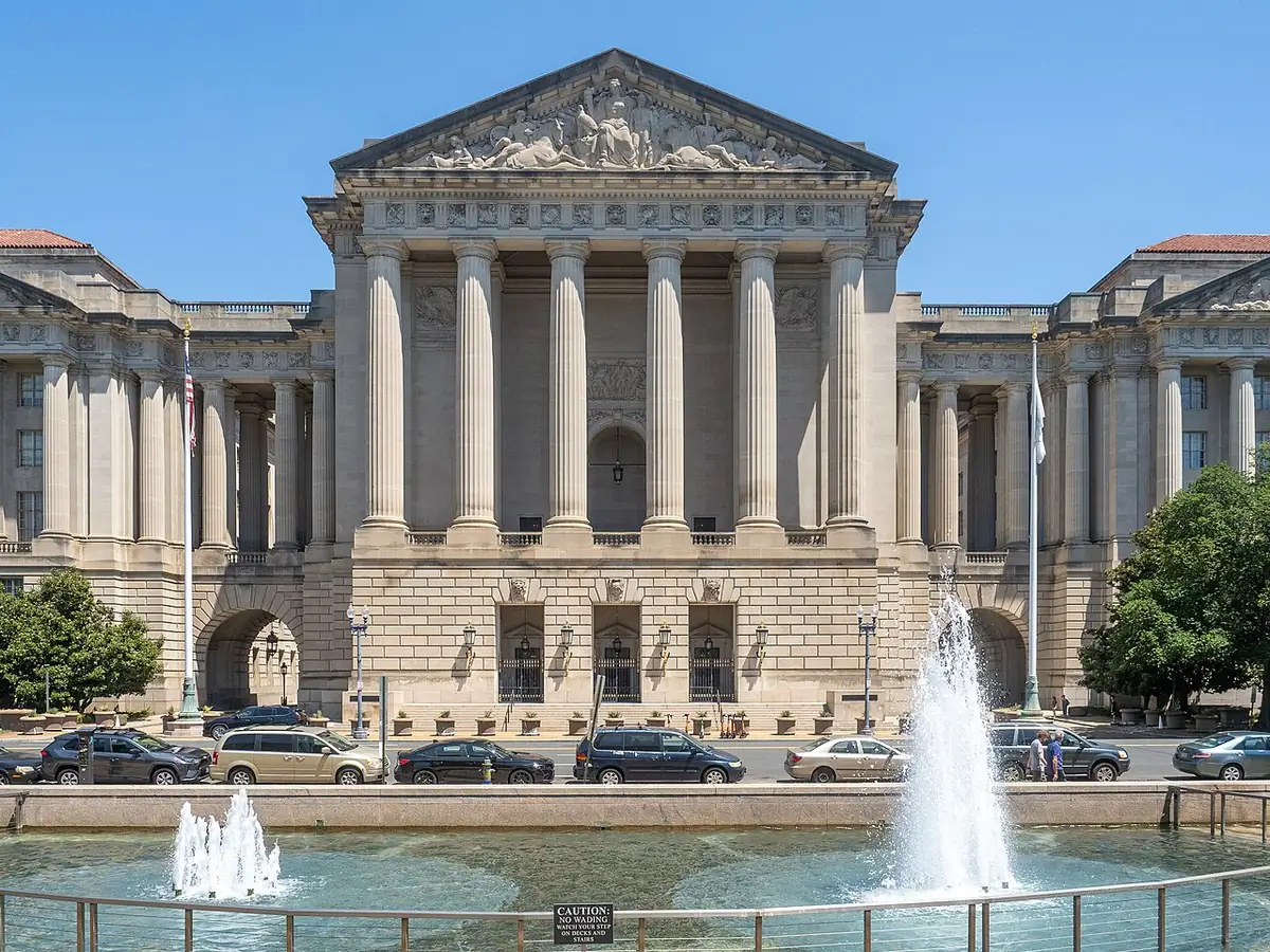 Neoclassical columned front of the Andrew W. Mellon Auditorium with fountains