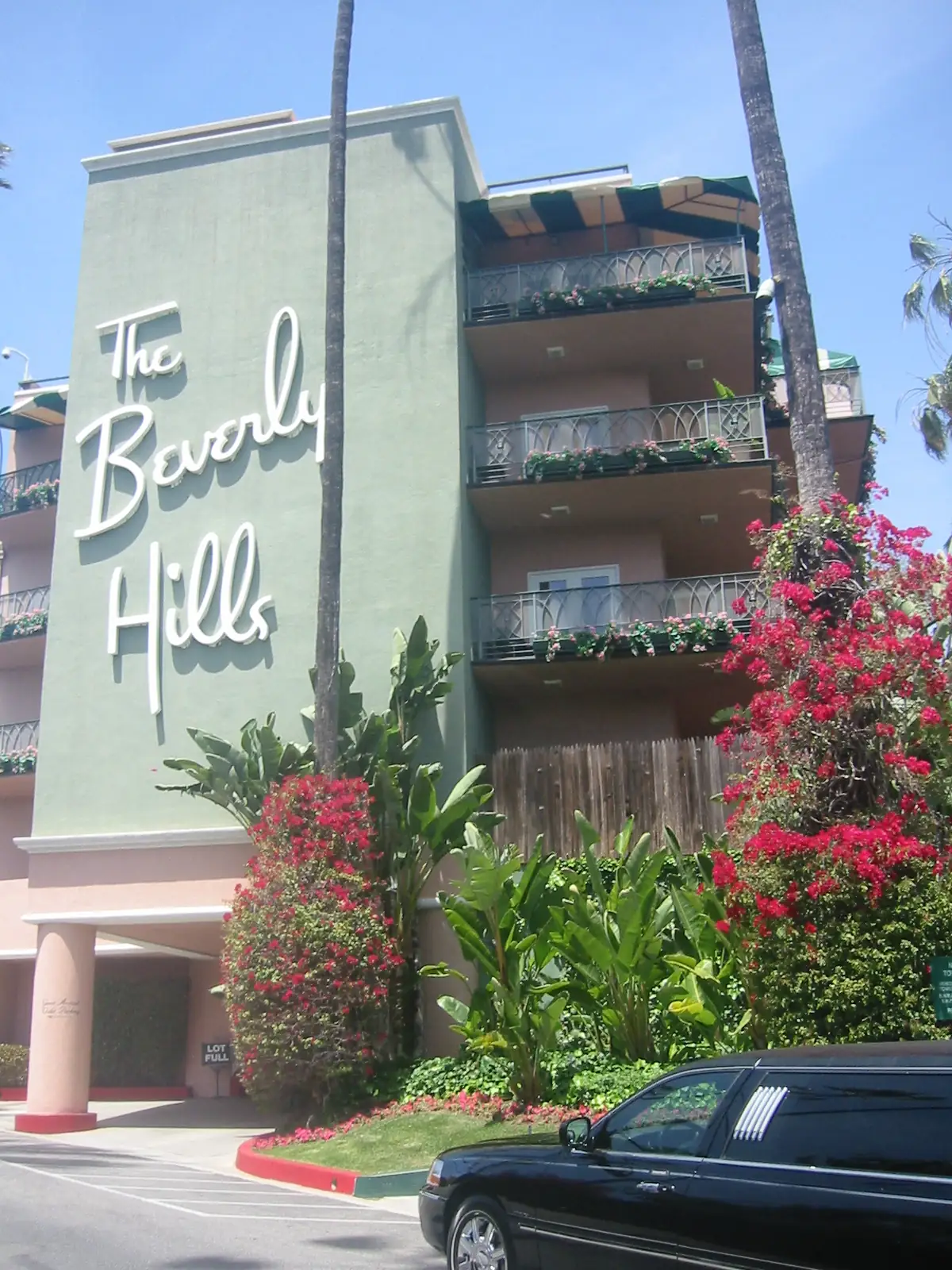 Pink-and-green wing of the Beverly Hills Hotel with its script sign and bougainvillea