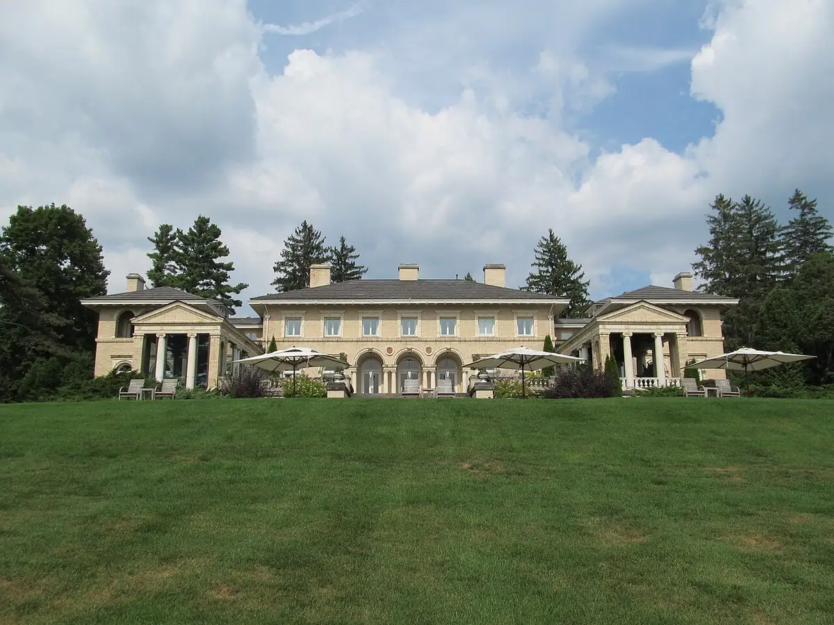 Cream Italianate Wheatleigh mansion with loggias seen across its lawn in Lenox