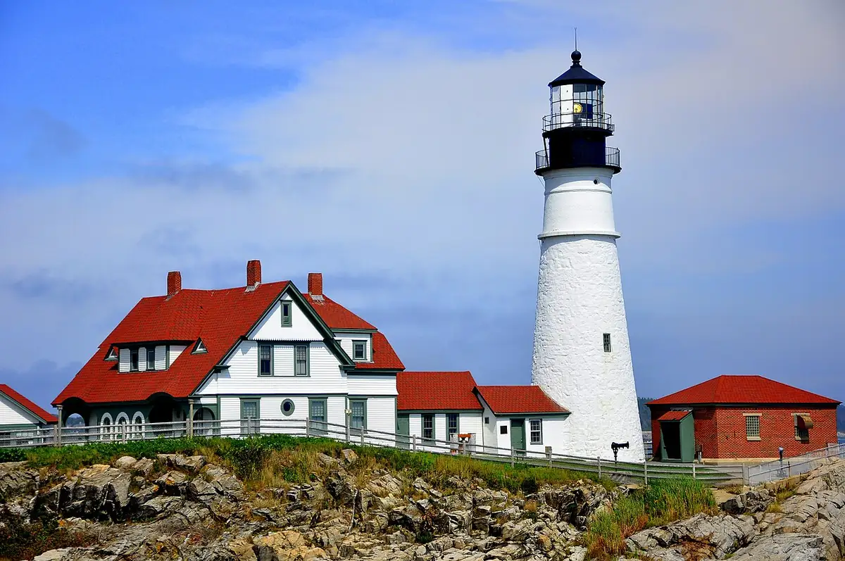 Portland Head Light tower and red-roofed keeper's house on the rocks at Cape Elizabeth